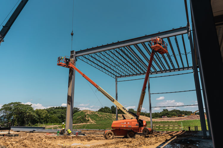A Dean Steel Erectors jobsite with cranes and steel framing
